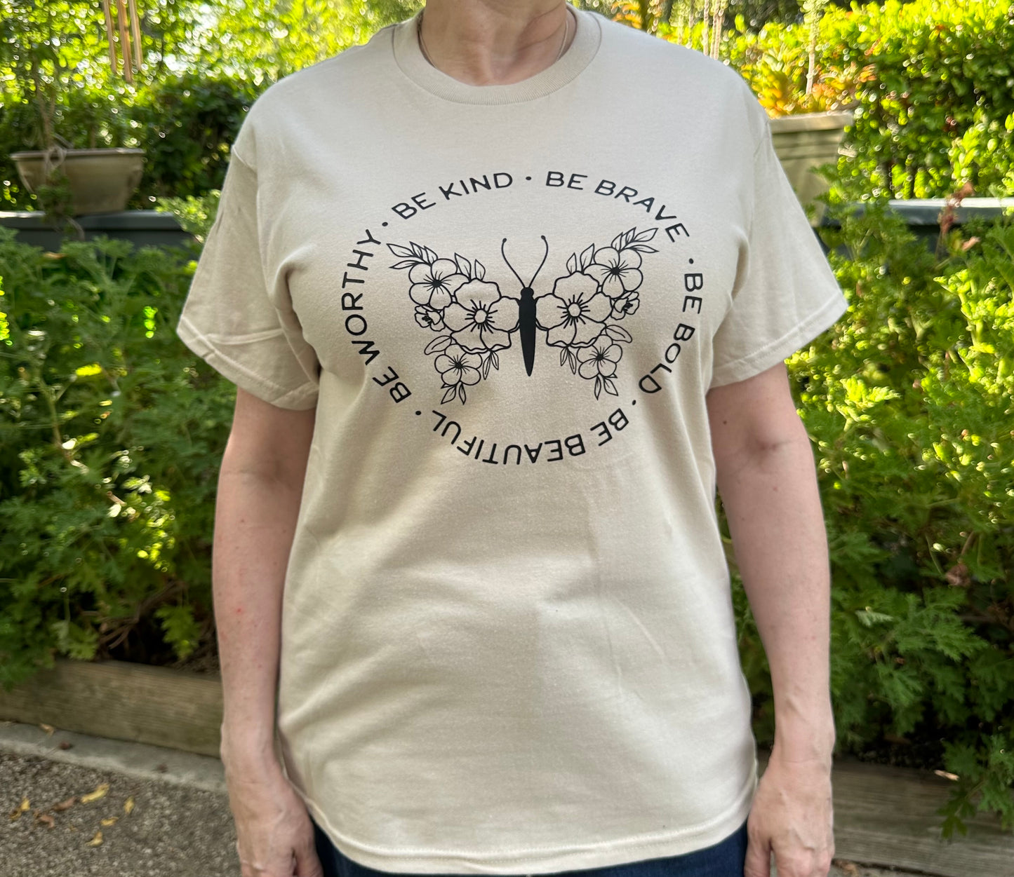 beige t-shirt with a motivational quote and butterfly design.