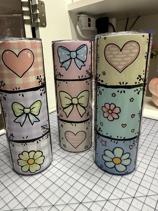 Colorful fabric rolls with heart, bow, and flower patterns on a grid background.