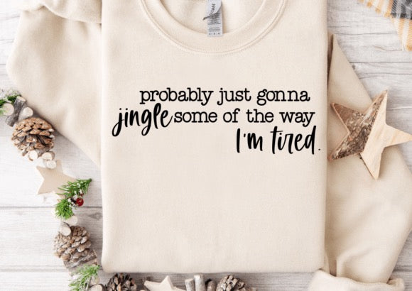 Beige sweatshirt with humorous text design on a wooden surface with decorative items.