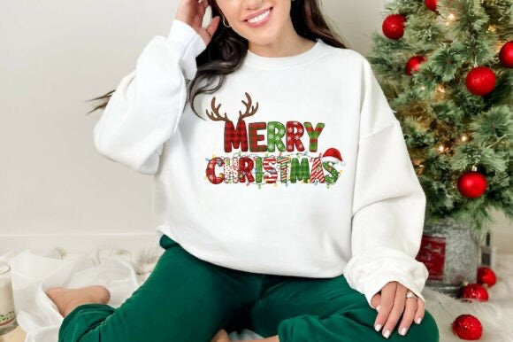 Person wearing a white sweatshirt with 'Merry Christmas' text and reindeer design in front of a decorated Christmas tree.