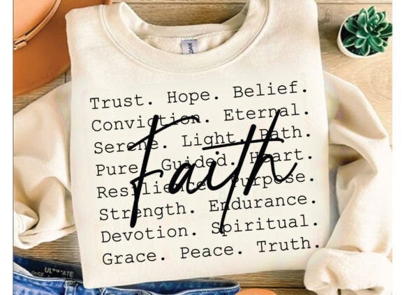 Beige sweatshirt with motivational text on a wooden surface